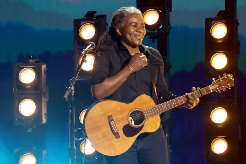 Image of Tracy Chapman, a black woman with long hair, playing acoustic guitar on a stage. This is a shot from the 66th Grammy Awards on Feb. 4, 2024 in Los Angeles, taken by Amy Sussman and credited to Getty.
