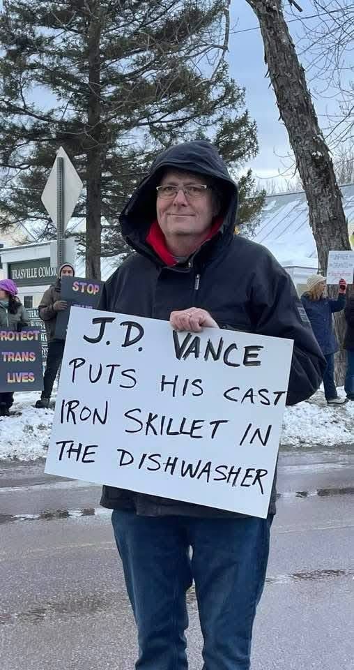 A protest sign that says “JD Vance puts his cast iron skillet in the dishwasher”