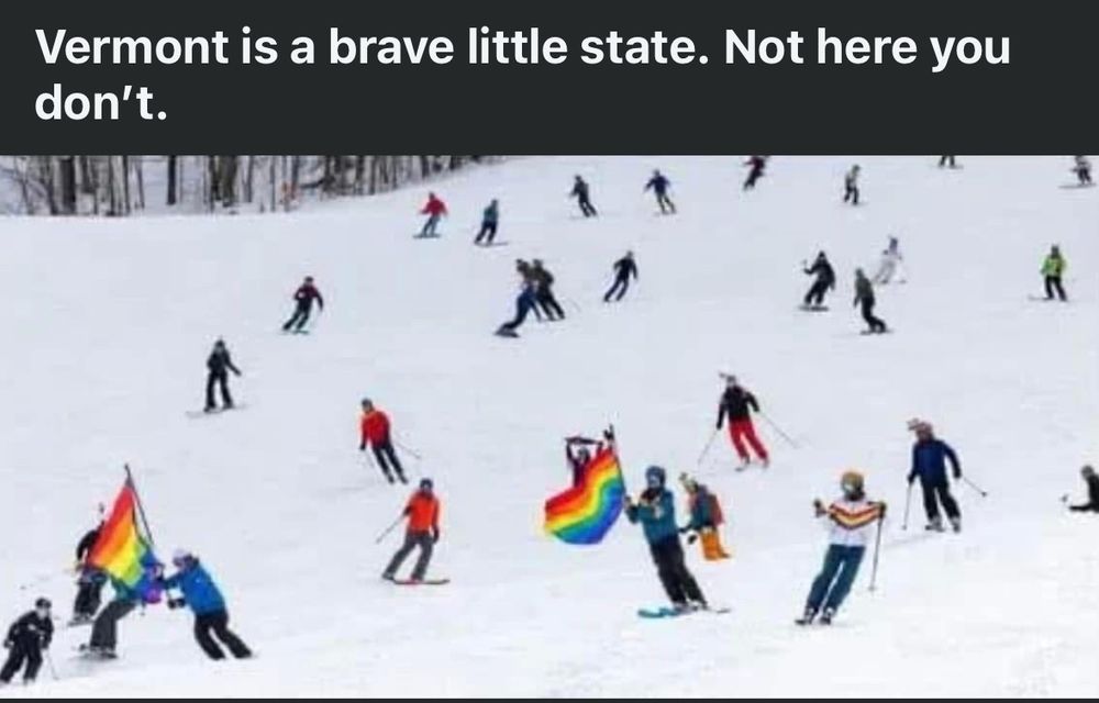 A ski slope that JD Vance visited with many people on it, some of whom are carrying LGBTQ pride flags