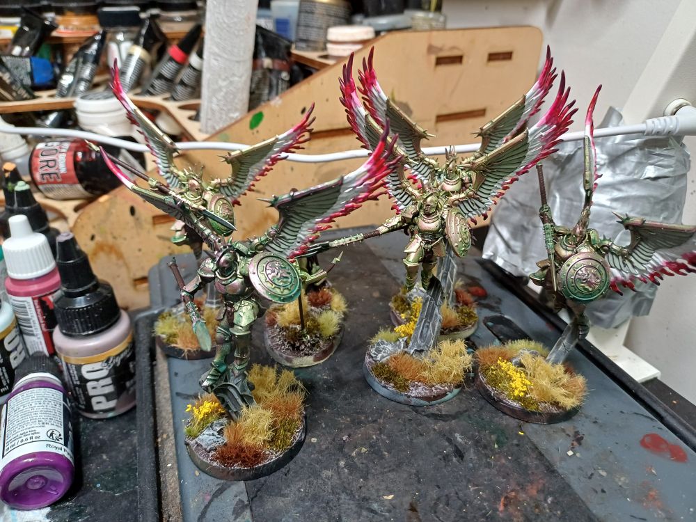A bunch of flying stormcast in highly weathered green gold armour, with white to red spectral wings
