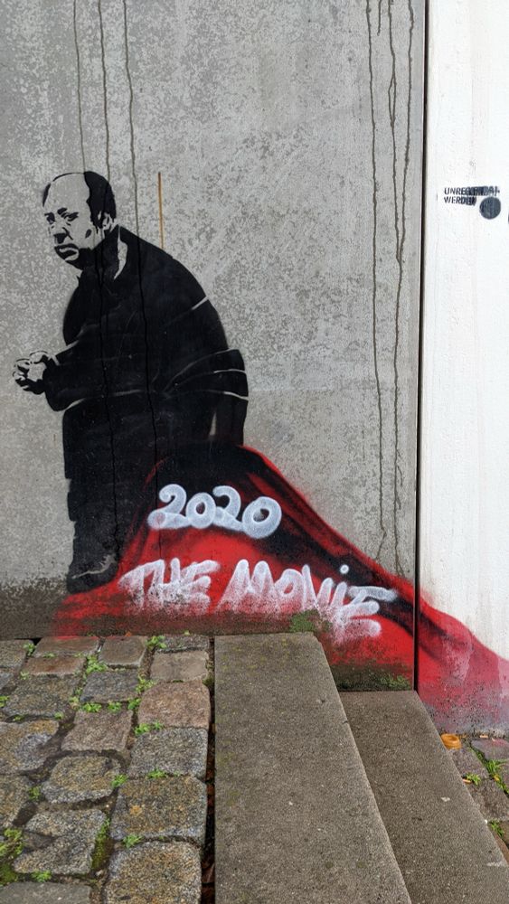 Street art Hitchcock on a pile of shit named “2020 - the movie”