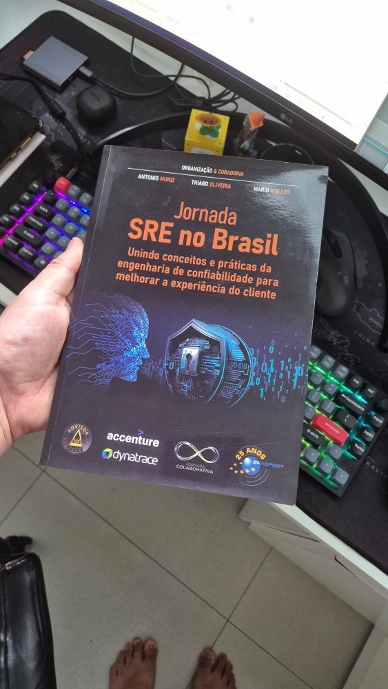 Foto do livro Jornada SRE no Brasil, com capa azul escuro com imagem do rosto de uma pessoa digitalizada e um escudo com uma fechadura no meio do escudo.