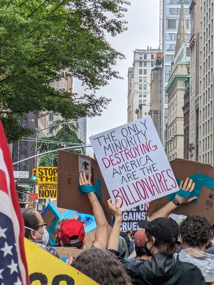 A sign saying, "the only minorities destroying America are billionaires"