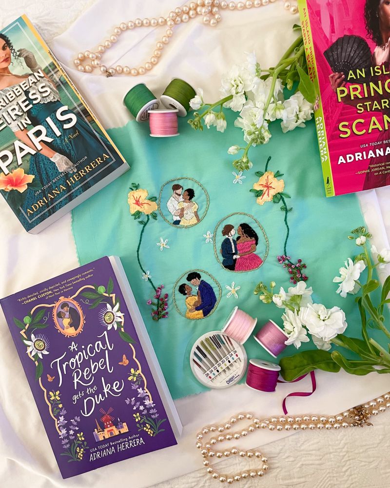 Embroidered art piece surrounded by three Las Leonas books by Adriana Herrera