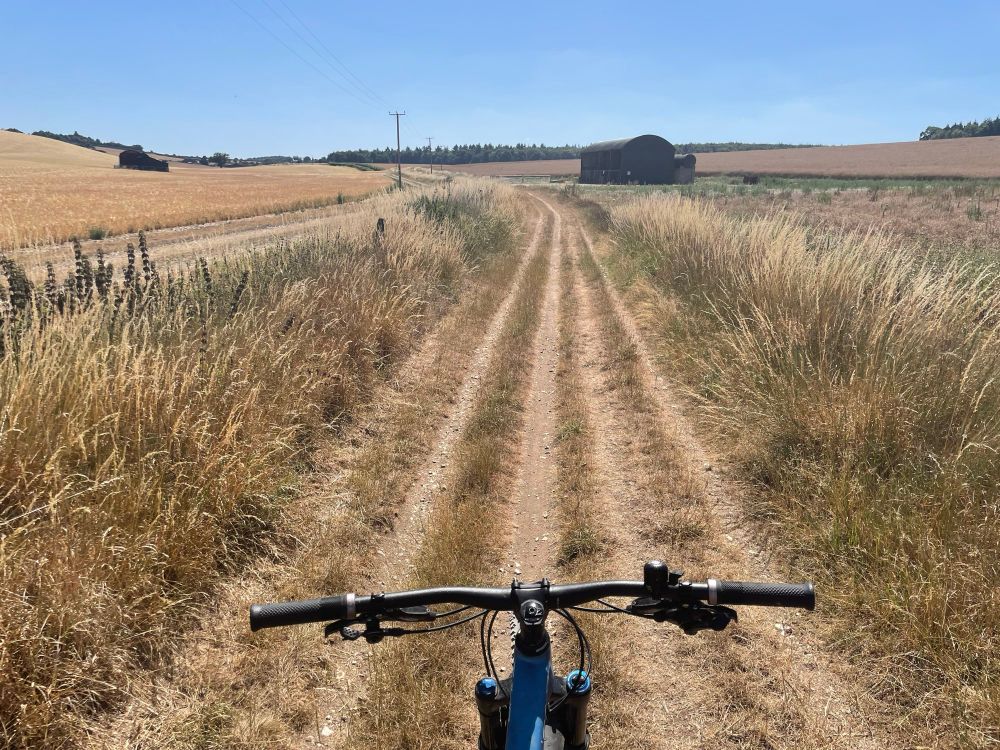 Bicycle handlebars with parched brown countryside beyond 
