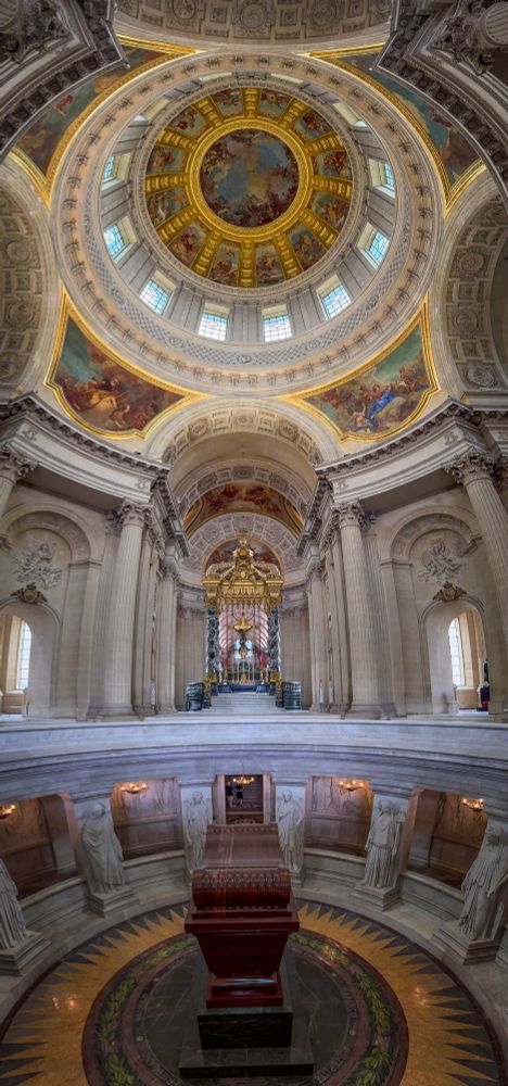 
Napoleon’s tomb. A huge chest like object sits a floor below surrounded by statues. Above it is a church-like room with a massive art and gold laid dome. 