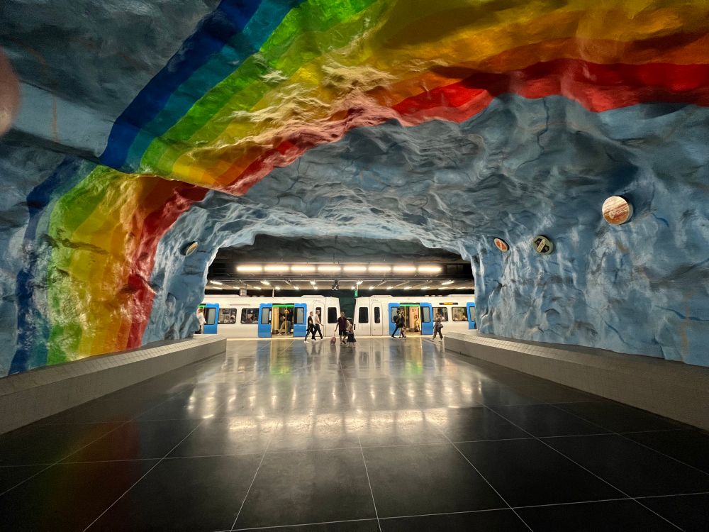 Inside Stadion metro station in Stockholm, which has a rainbow painted on its cave-like roof
