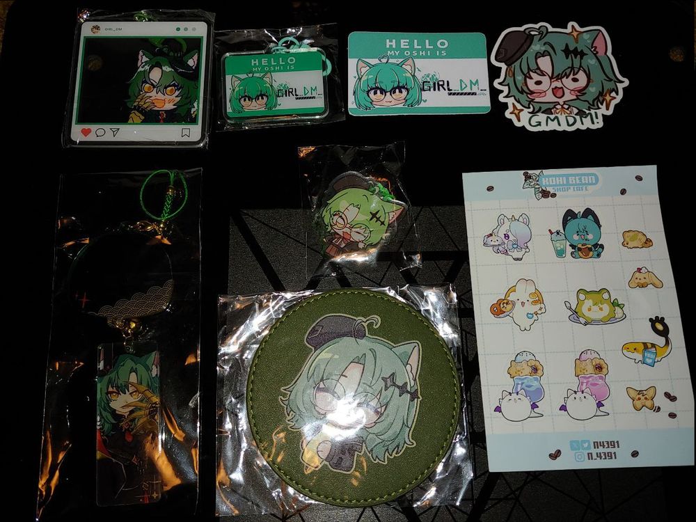 Girl_DM_ OffKai merch
Top 4 are: Villainess overlay, Oshi charm, Oshi sticker, MelonMinty DM sticker
Middle small one is: Kyu DM charm
Bottom 3 are: Villainess 2 piece hanging charm, Coaster, Kohi sticker set (with one of DM)