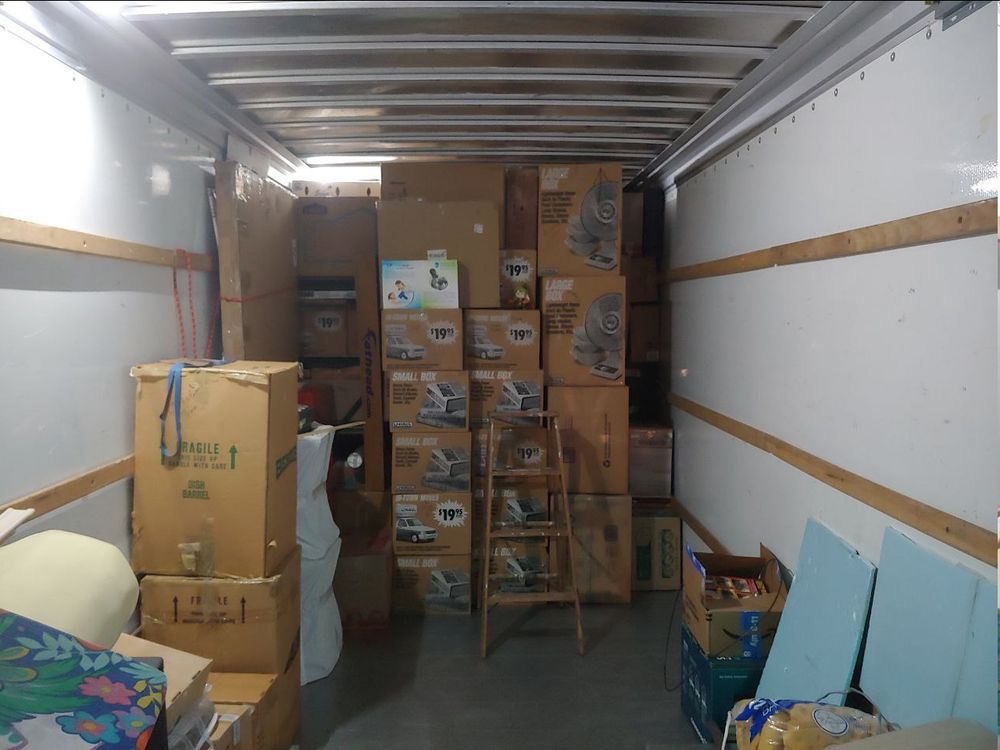 Boxes filling half of the truck with the Girl_DM_ nui in the center on top of boxes.