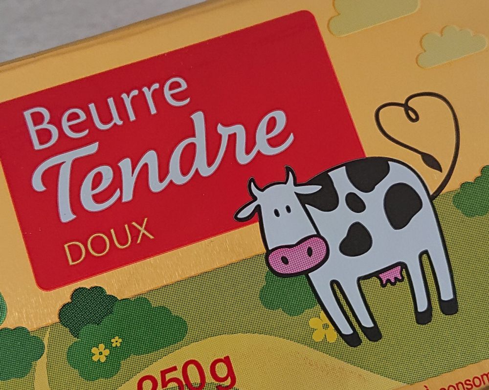 Photo d'une plaquette de beurre doux et tendre, illustrée avec une petite vache mignonnette qui fait un cœur avec sa queue. Concentré de choupitude. Certains diront que c'est vraiment un beurre de babtous fragiles. Je pense personnellement qu'il y a en chacun de nous une part de fragilité qu'il est important d'assumer pour exister à part entière en tant qu'humain. En plus le beurre tendre c'est plus facile à tartiner et ça c'est vraiment cool.