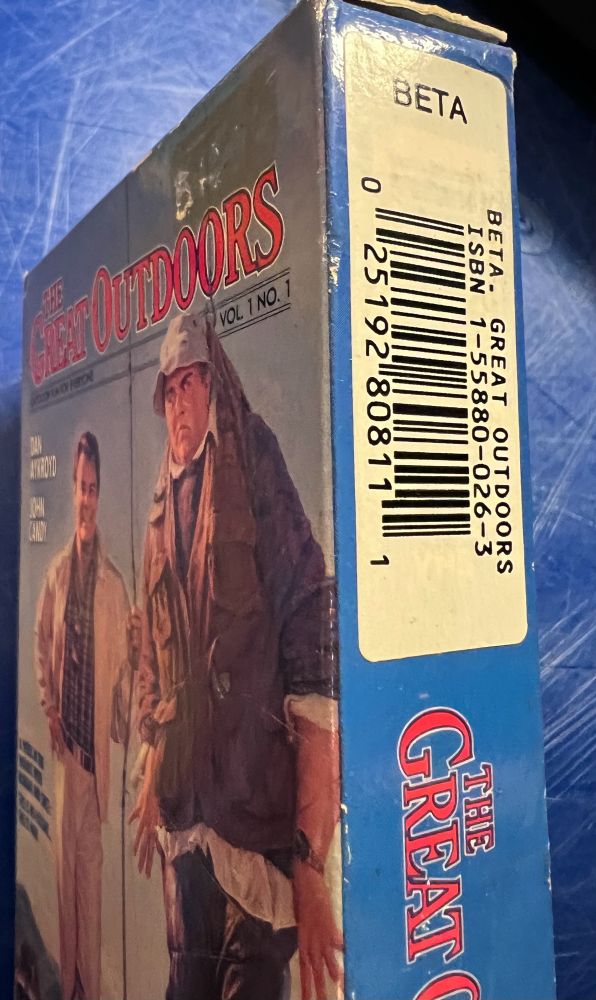 Picture of a betamax video tape of the 80s John Hughes movie The Great Outdoors, with a barcode sticker on the side of the box