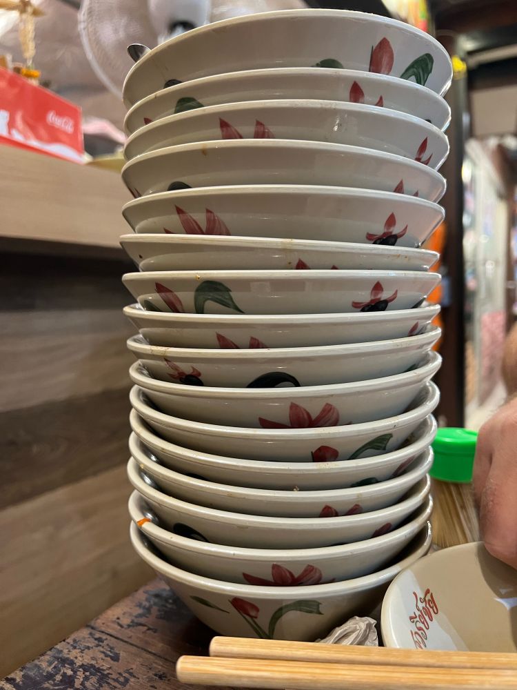 A stack of 16 emptied noodle bowls