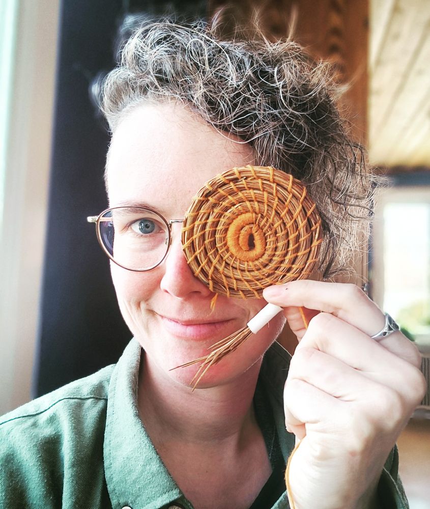 A portrait of me while holding a basket bottom over one eye.