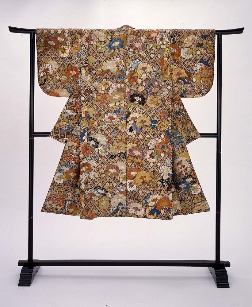 Dark brown silk Noh theater robe with overall design of peonies on cypress fence in green, blue, light brown, purple, orange, white, pink and gold supplemental weft patterning with some later embroidery. There is a reddish-orange plain-weave silk lining.