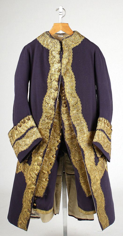 This magnificent suit remarkably survives complete with all of its components. Because elements of menswear were often retailored to accommodate changes in the wearer's size or in fashion, this ensemble in essentially unaltered condition is an exceedingly rare example. Characteristic of the fashion of this date, skintight breeches that buckle below the knee and a fitted waistcoat are almost entirely covered by a coat with collarless, narrow chest and stiffly flaring skirt that concentrates emphasis on the lower torso and thighs. The placement of the opulent applied decoration bolsters this effect. Although the coat retains stiffness reminiscent of the 1750s styles, the buttons do not meet below the upper chest and the angular opening anticipates the pronounced front curve and diminishing skirt of late decades. The color coordination of all three parts and the utilization of wool, both decidedly English elements that anticipate modern attire, were generally reserved for informal wear. Here, however, the suit is resplendent with an abundance of gold buttons and braid more closely associated with high-style occasions.