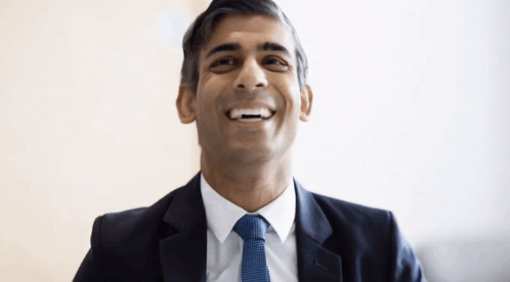 a man in a suit and tie is smiling with his mouth open