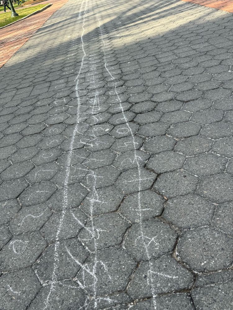 University sidewalk with the digits of π written out in chalk.