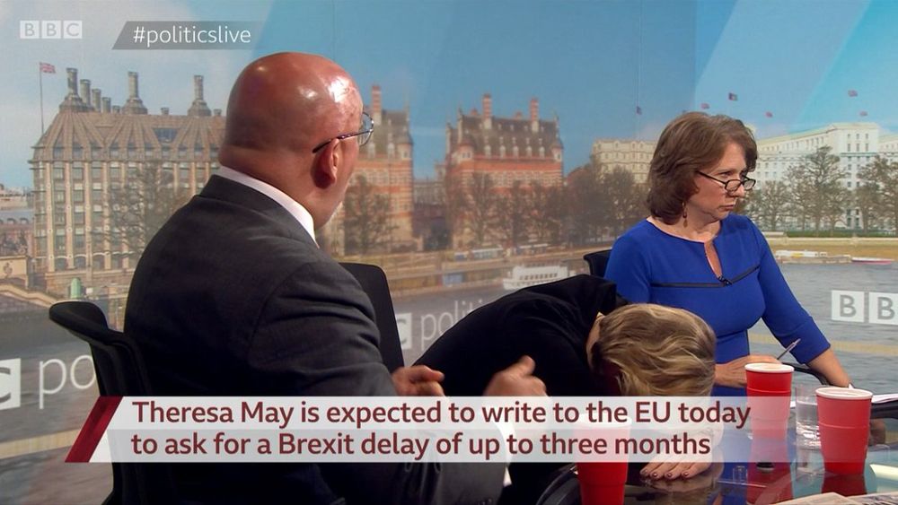Nadhim Zahawi attempts to make a point during yet another Brexit discussion on the BBC show Politics Live. The caption says, 'Theresa May is expected to write to the EU today to ask for a Brexit delay of up to three months'. Presenter Jo Coburn looks politely fed up of Zahawi's insistence that the UK can seek a magical Brexit that isn't actually a disaster. The other guest has planted their head on the desk.