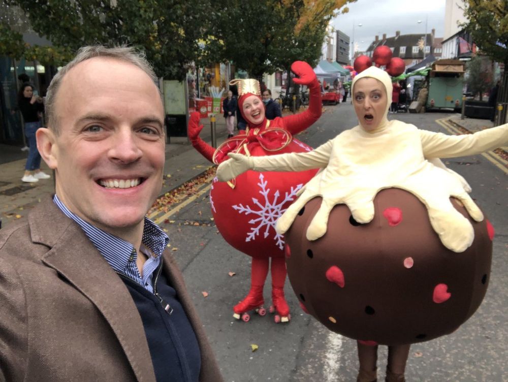 Dominic Raab taking a selfie with some people dressed up as gigantic Christmas tree baubles.