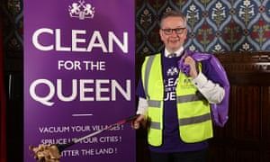 Michael Gove holding a duster with a smile, in front of a banner that says, 'Clean For The Queen'.