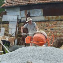 Our friend Bob mixed the stone, cement and water in a cement mixer to make concrete which the rest of us poured into the frame made to hold it and firm the concrete 
