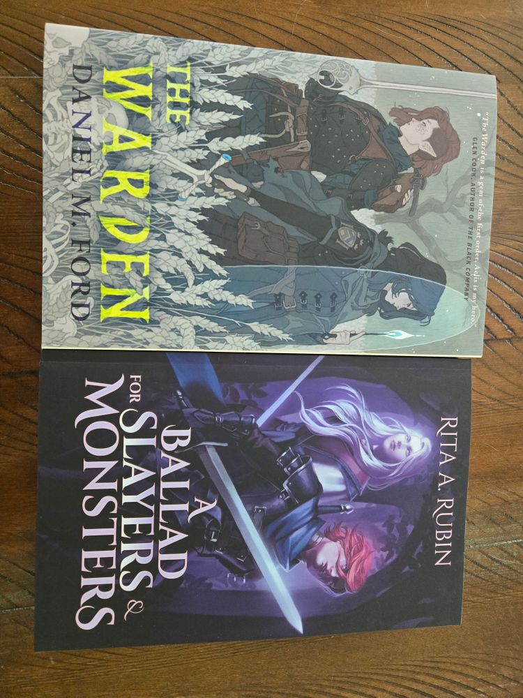 The Warden by Daniel M Ford and A Ballad for Slayers and Monsters by Rita A Rubin, side by side on my table