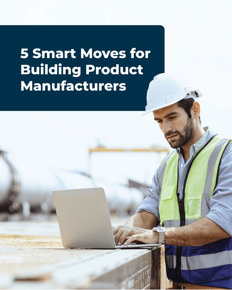 A man wearing a white hard hat and green safety vest types on a laptop placed on a wooden surface at an industrial site. Above him, the text reads, "5 Smart Moves for Building Product Manufacturers." In the background, blurred industrial tanks and equipment are visible.