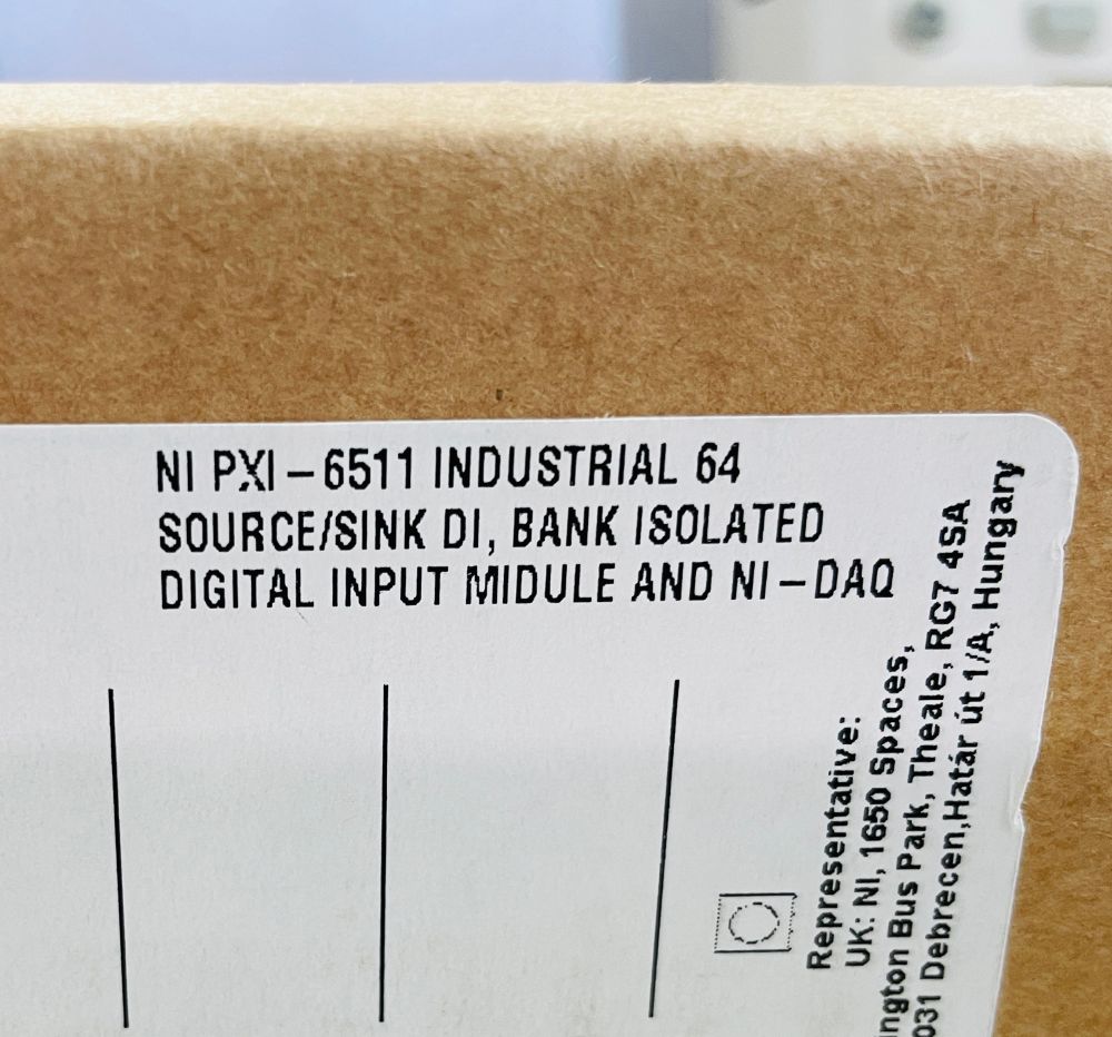 Close up photo of the part description sticker on National Instruments packaging. The word module is misprinted as "midule". The description reads "NI PXI - 6511 INDUSTRIAL 64 SOURCE/SINK DI, BANK ISOLATED DIGITAL INPUT MIDULE AND NI - DAQ"