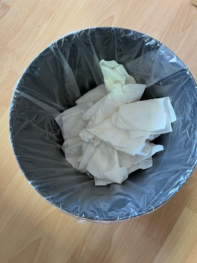 Mülleimer voll mit benutzten Taschentüchern. 