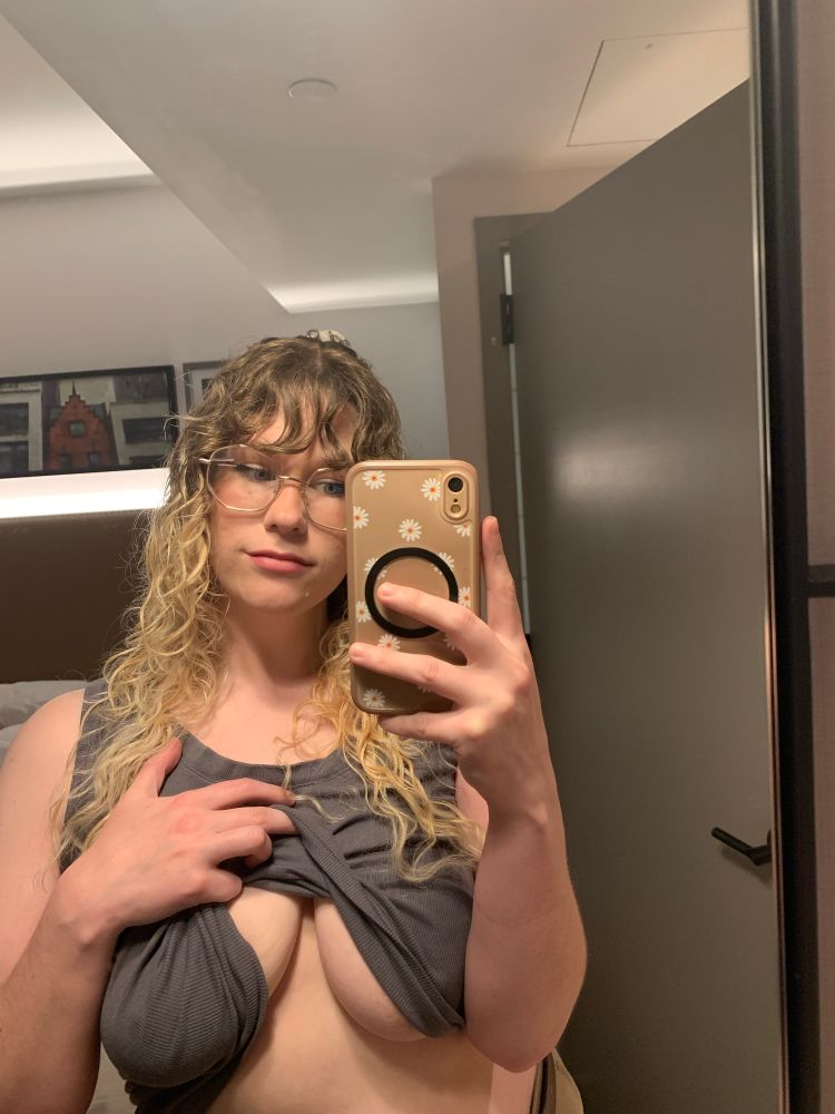 mirror selfie of gossy pulling up a grey tank top 