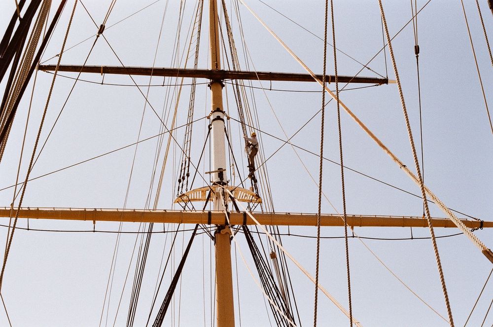 A very small rigger on a very tall ships mast. 