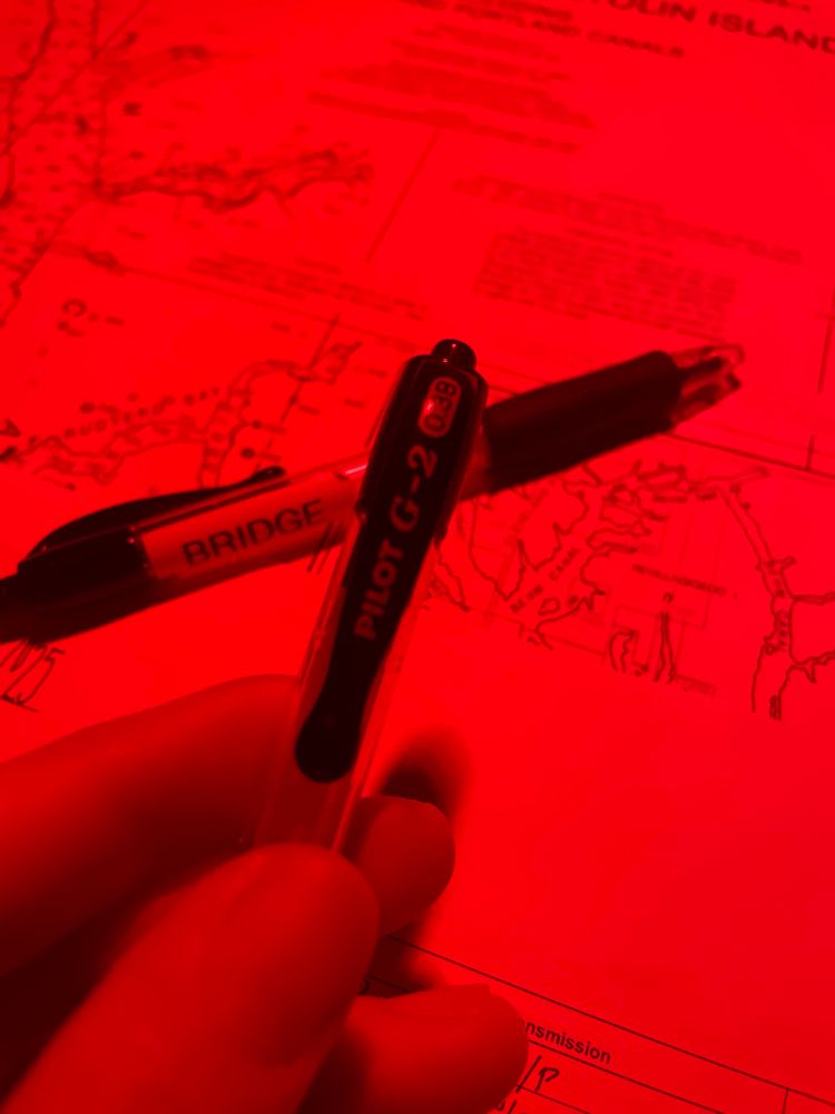 A pilot G-2 .38mm pen illuminated under the red lights of a ships bridge. 