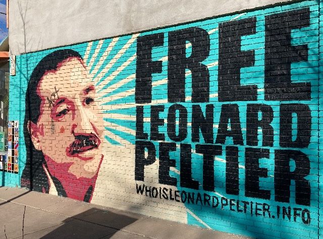 A mural depicts Leonard Peltier with the words “Free Leonard Peltier”
