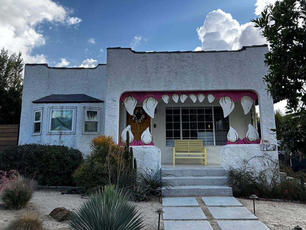 A house with a set of giant, sharp teeth and red gums makes the front porch look like a ferocious, open mouth. 