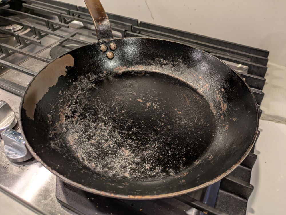 Carbon steel pan with flaking seasoning