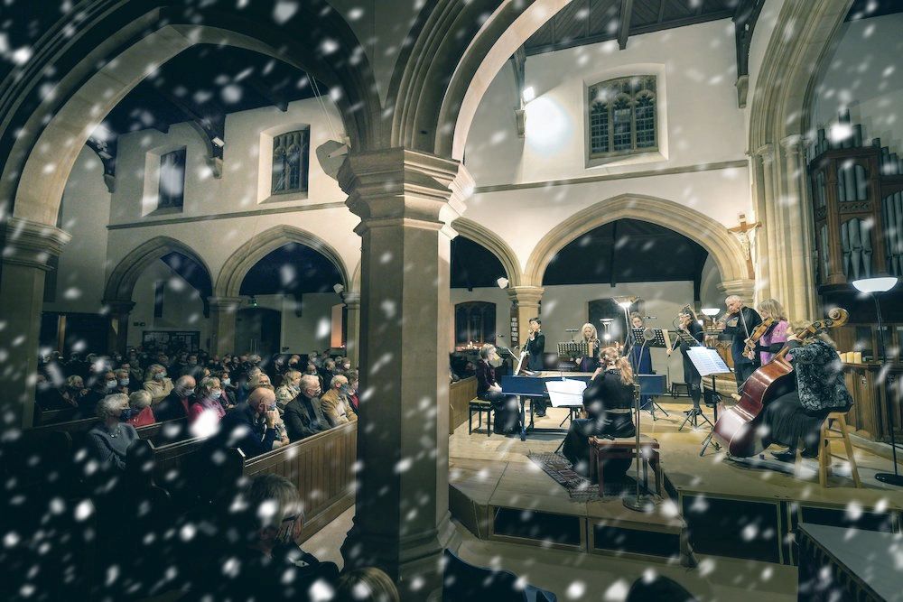 Classical musicians in a church, with a snow effect superimposed over the top