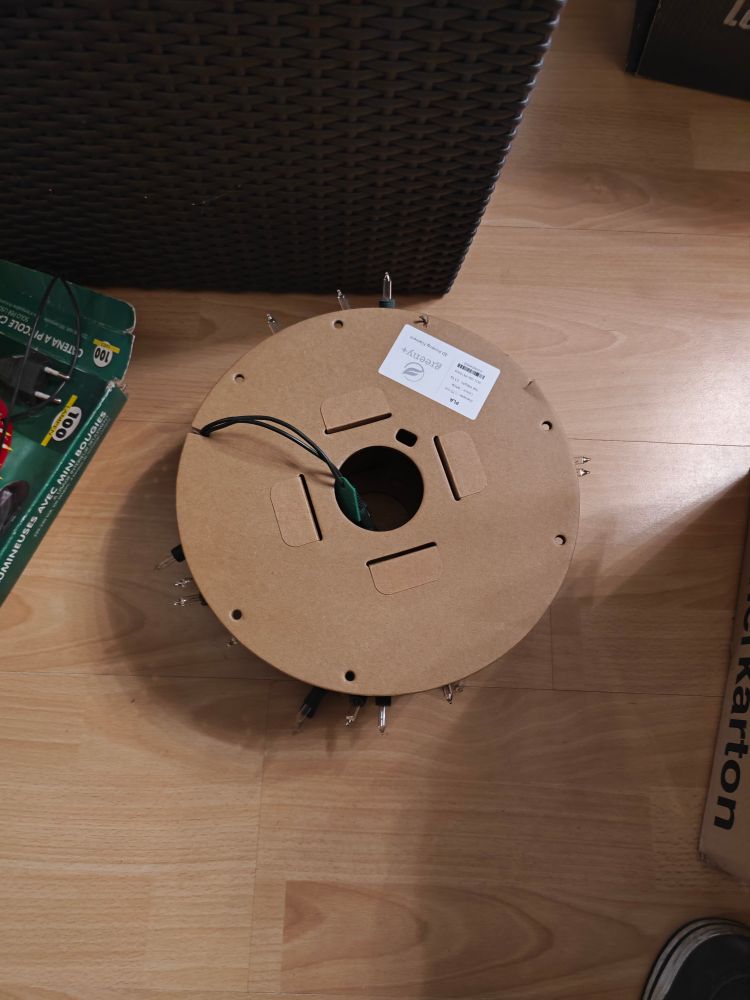 Das Bild zeigt eine Rolle aus Pappe, auf der ursprünglich 3d Druck Filament aufgerollt war. Jetzt ist eine lichterkette aufgerollt. 