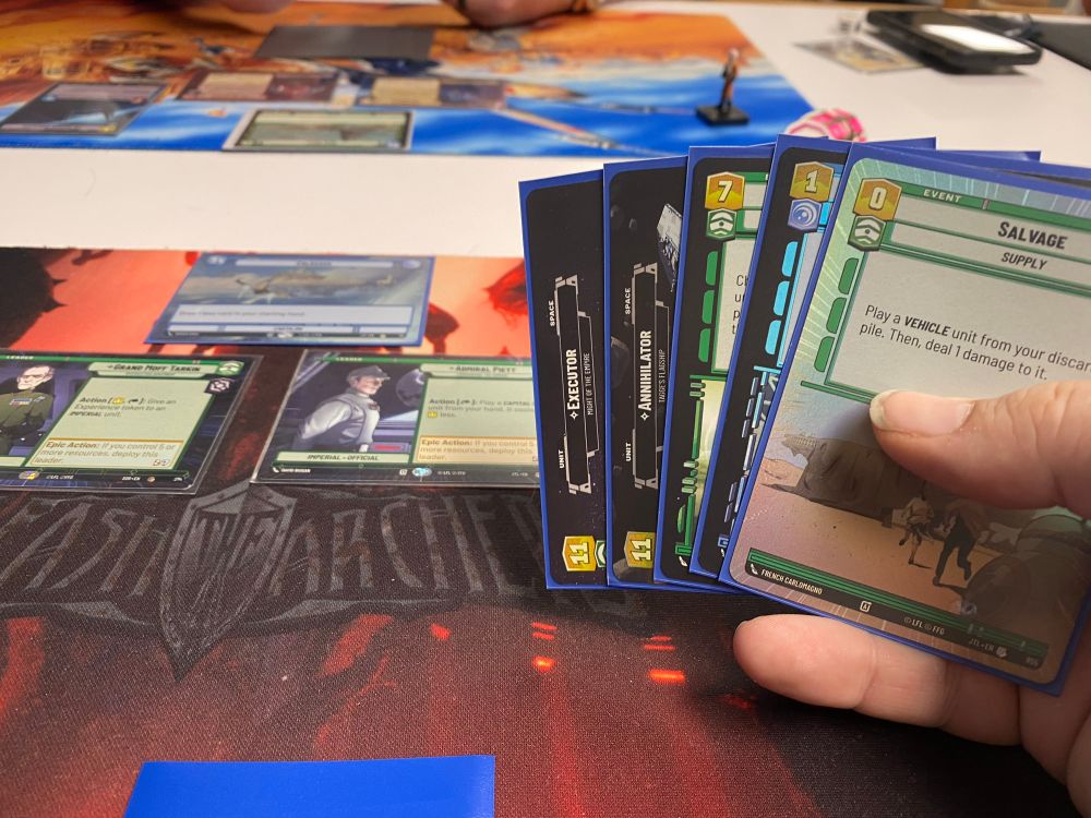 A hand of cards in SWU, showing Salvage, Executor, Annihilator the cost for Turbolaser Salvo and Closing the Shield Gate. Background is Tarkin Leader and Piett Leader.