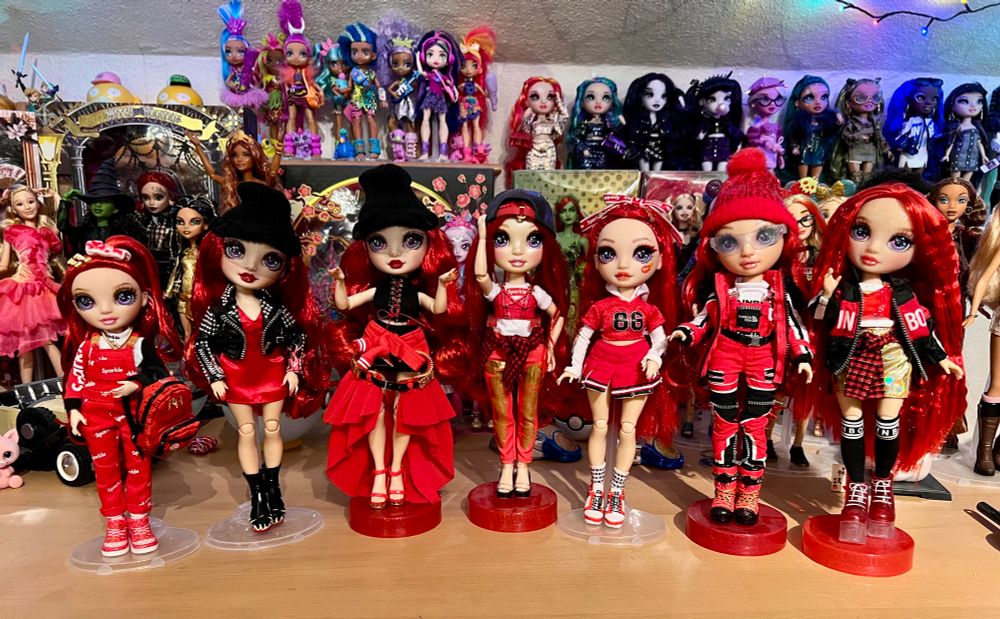 A collection of several Ruby Anderson in front of a lot of other dolls.