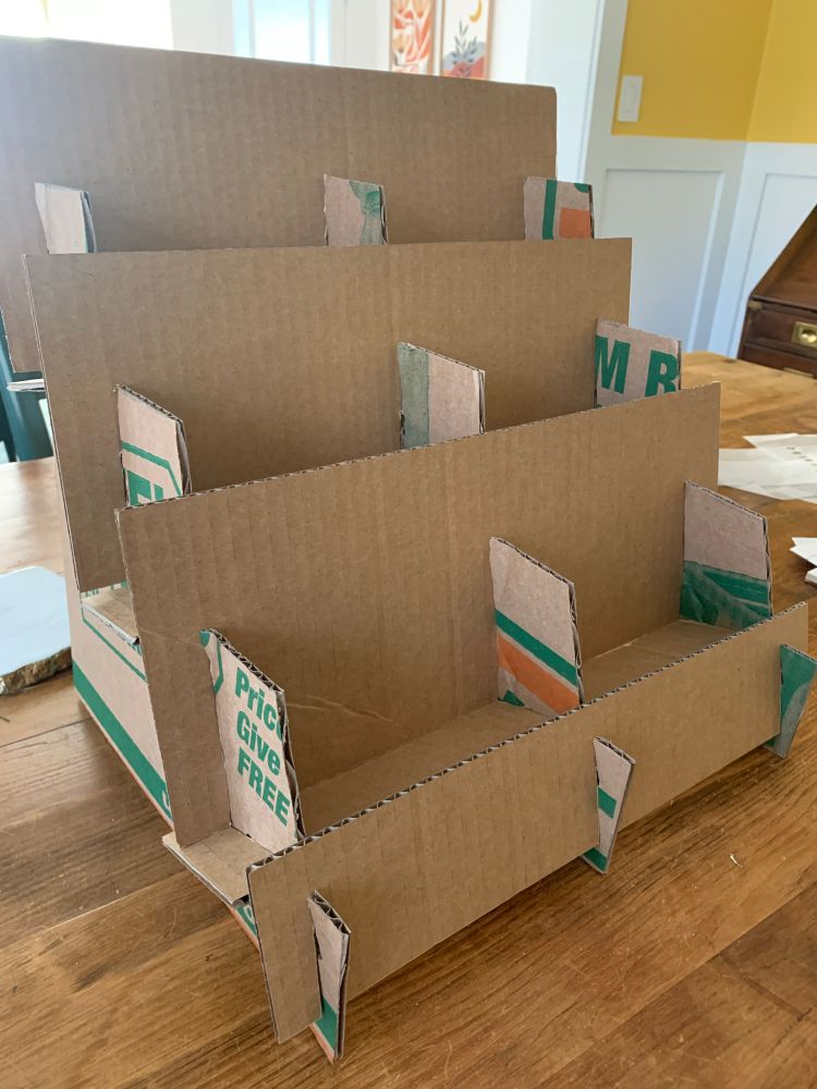 A simple corrugated cardboard structure intended to display zines at a fair. It is a simple stair-step bookshelf made out of a cut-up UHaul moving box.