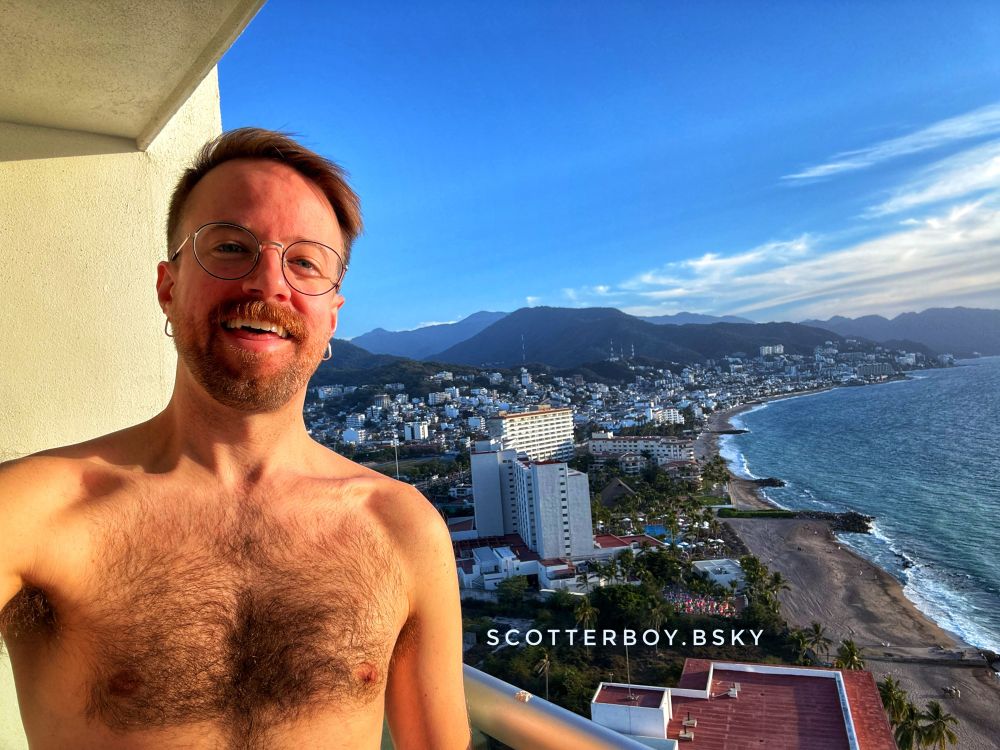 Selfie on a hotel balcony overlooking the city.