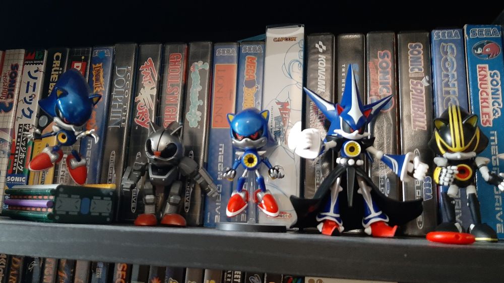 A grown man's collection of figurines of Metal Sonic from Sonic the Hedgehog, lined up on a shelf of Mega Drive games