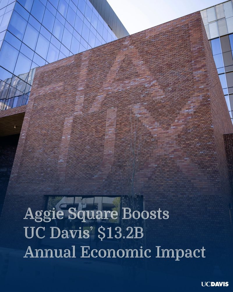 A brick mural of the Latin phrase Fiat Lux at Aggie Square. A blue gradient with white text reading "Aggie Square Boosts UC Davis’ $13.2B Annual Economic Impact" is placed at the bottom with the UC Davis logo.