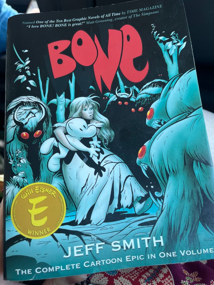 Cover of the graphic novel Bone by Jeff Smith. A girl is holding a creature & is surrounded by monsters. 