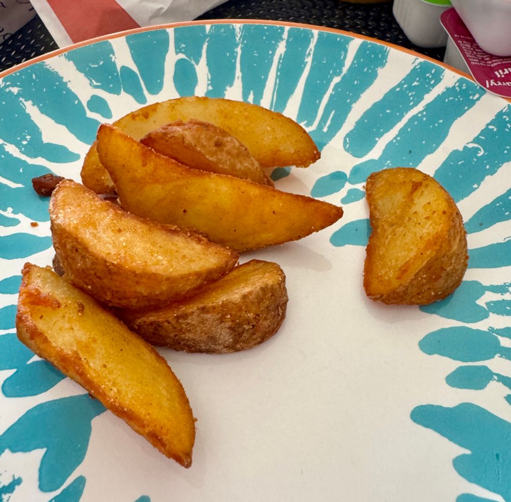 Some very tasty little potato wedges on a plate (in Paris)