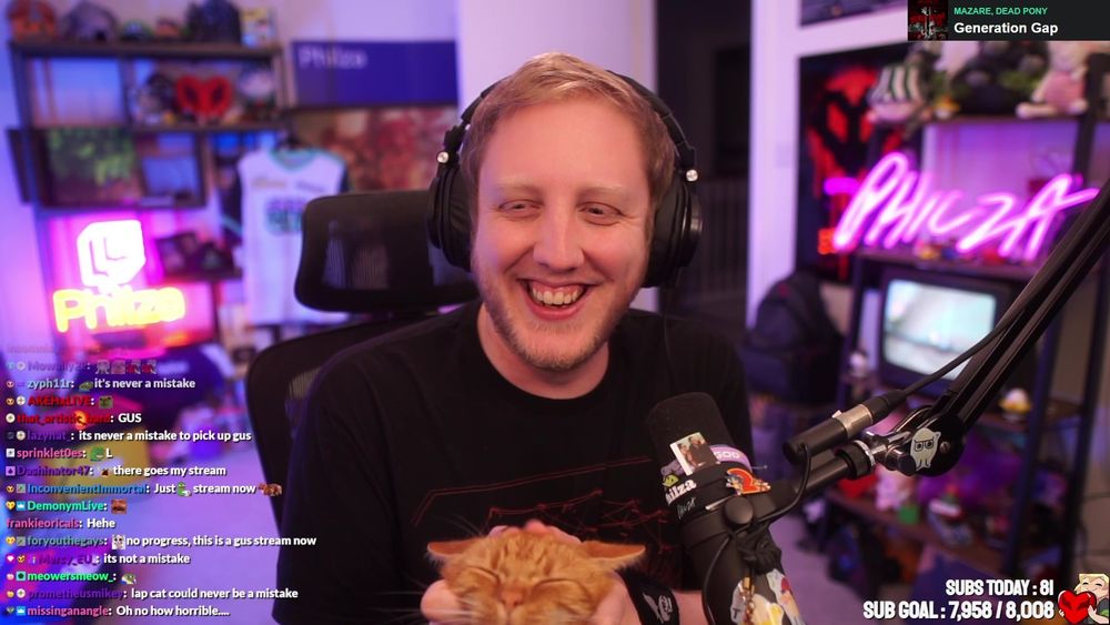 screencap of Philza in full-screen mode petting Gus. Philza is laughing Gus is the happiest cat imaginable (2 orange cats according to chat lmao)