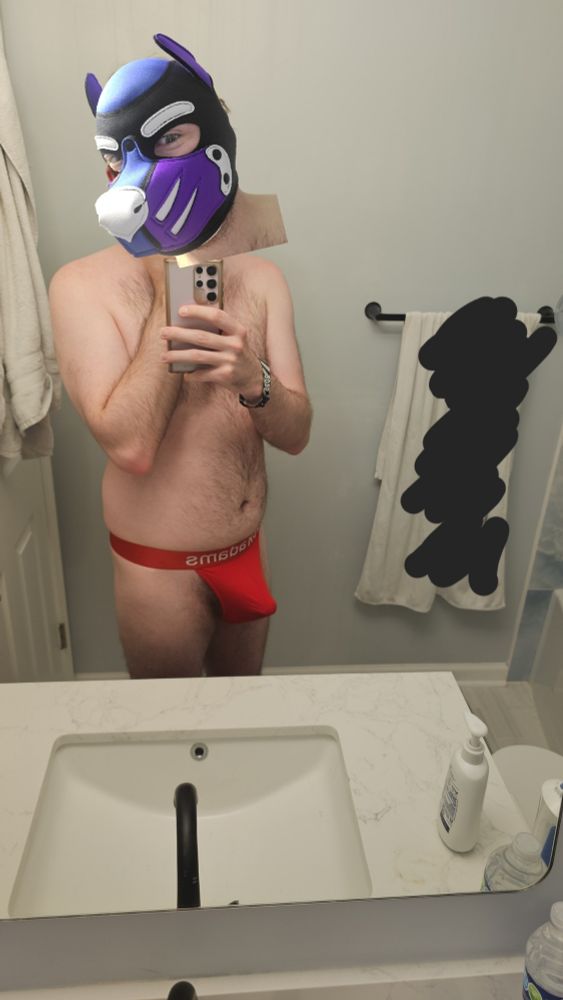 Knight taking a picture of himself in the mirror with his morning wood tenting up a red Jack Adams brand thong.