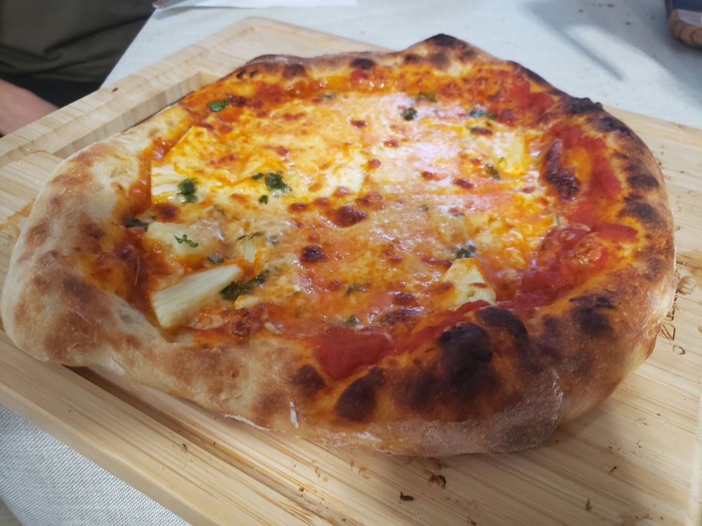 Homemade pizza, lovingly loaded with cheese and pineapple