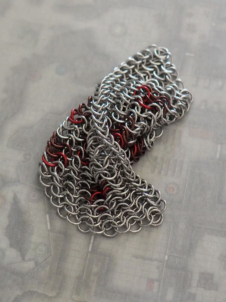 the same pizza fidget folded over upon itself. this shows the flexibility of the fabric and the crust. no playing card this time, it sits on top of a dnd map with a semi translucent white paper on top to give the effect of fading color.
