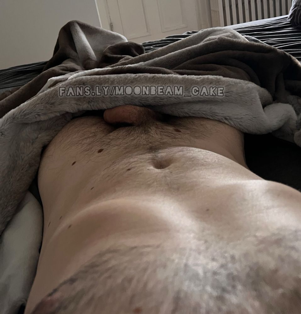 Moonbeam lying naked on his back, sheets covering his legs up to his thighs, just enough to expose his semi hard resting cock